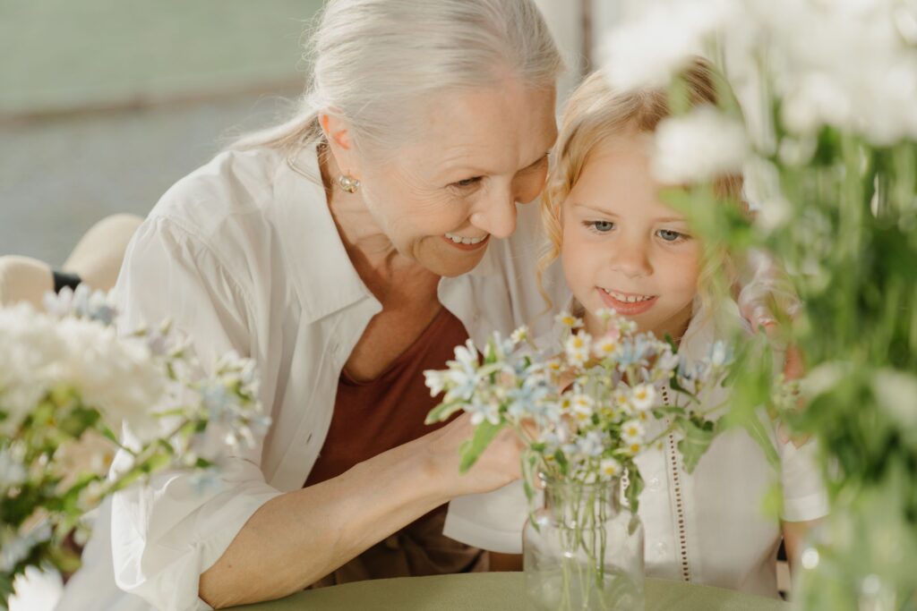 Oma und Enkelin binden Blumensträuße