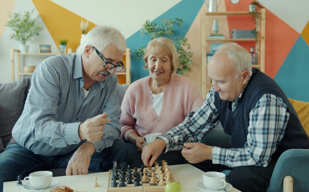 Drei ältere Personen beim Schachspielen