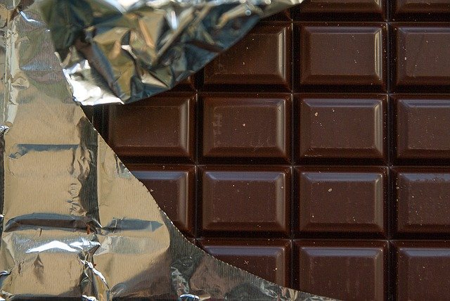 Vollmilchschokolade wird von Alufolie ummantelt. 