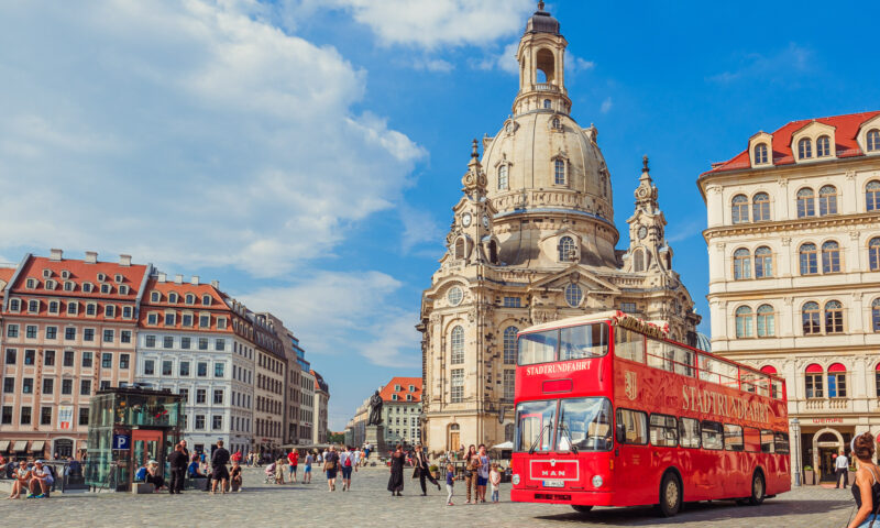 Der rote Doppeldecker Bus der Stadtrundfahrt Dresden vor der Frauenkirche.