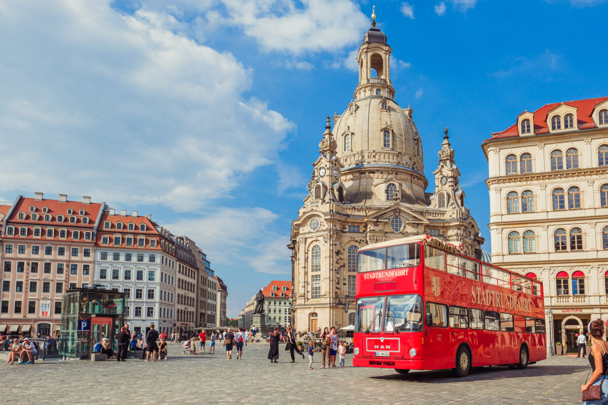 Der rote Doppeldecker Bus der Stadtrundfahrt Dresden vor der Frauenkirche.