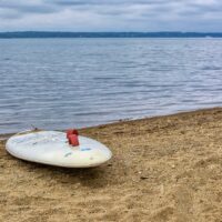 Ein Paddle Board am Ufer eines Sees.