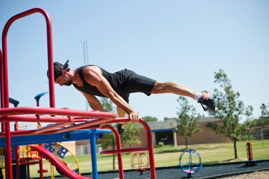 Ein Sportler trainiert mit seinem eigenen Körpergewicht an Geräten eines Sportparks.