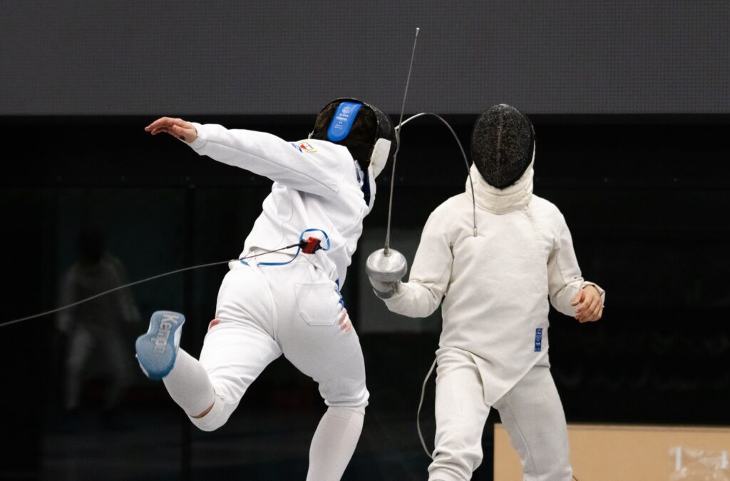 Zwei Fechtsportler im Duell in weißer Trainingskleidung.
