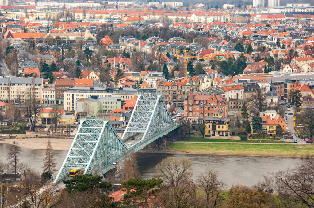 Die Brücke "Blaues Wunder" in Dresden, der Landeshauptstadt Sachsens aus der Vogelperspektive mit dem Häusermeer der Innenstadt im Hintergrund und dem Flussbett der Elbe