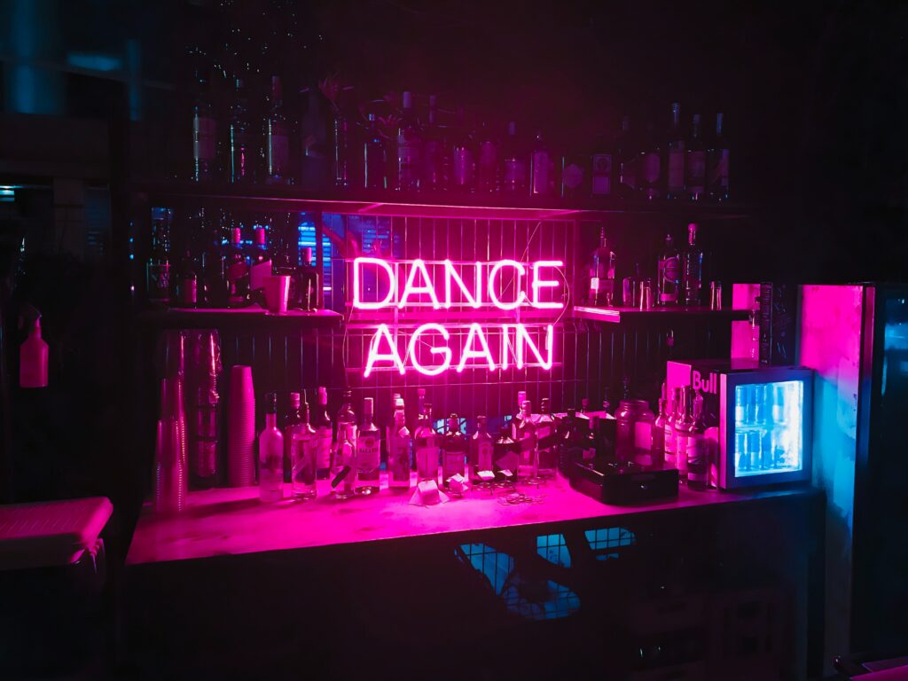 Eine Bar mit dem leuchtenden Schriftzug "Dance Again".