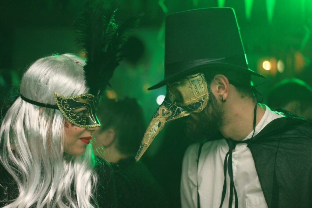 Verkleidete mit Masken auf einer Feier