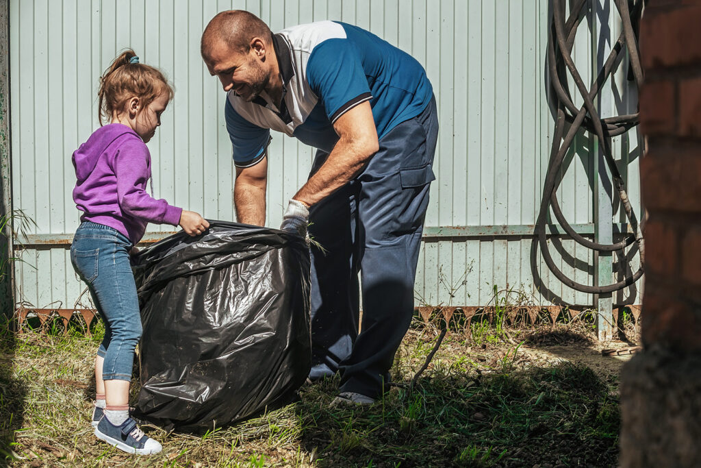 Familie sammelt Müll im Garten
