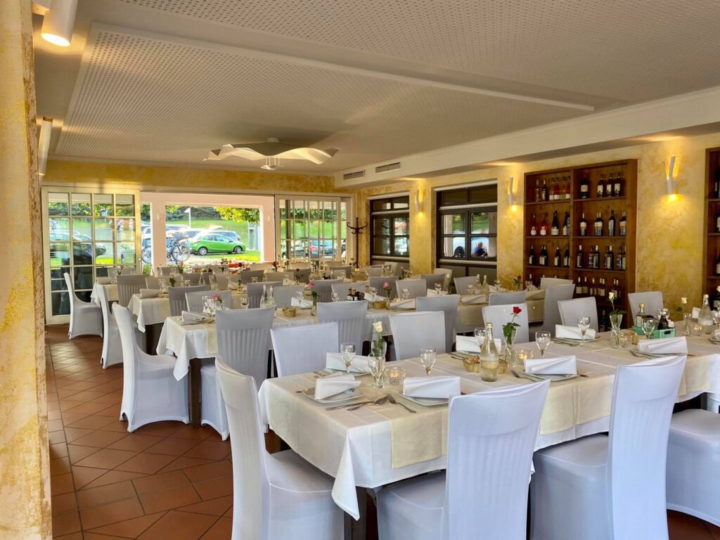 Blick auf weiße Stühle und Tische im Restaurant am Lucknerpark