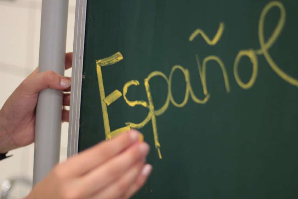 Jemand schreibt das Wort "Espanol" an eine Tafel
