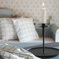 Kerzenständer und Küchentuch vor einem schwedischen Sofa