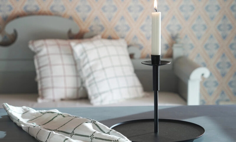 Kerzenständer und Küchentuch vor einem schwedischen Sofa