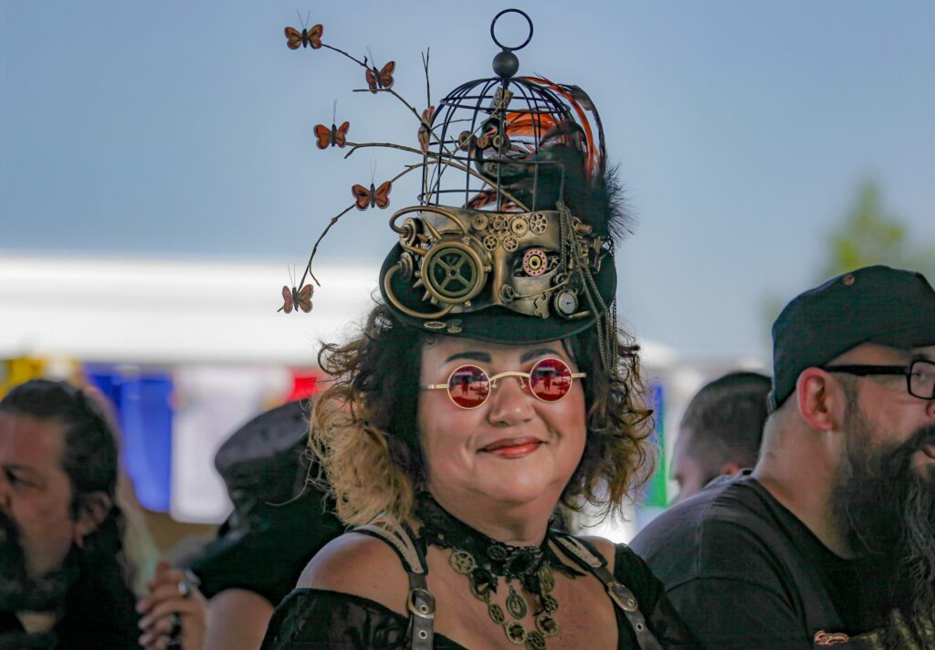 Frau im Steampunk-Outfit mit tollem Hut auf dem Kopf