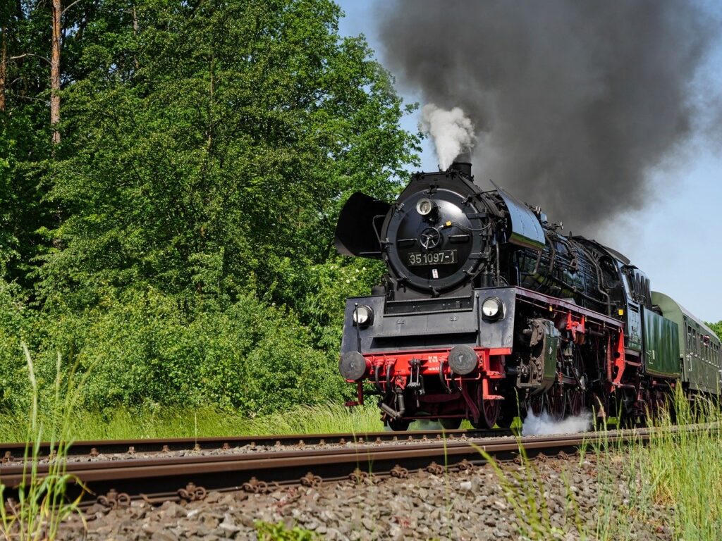 Schwarze Dampflokomotive mit Rauch auf Schienen