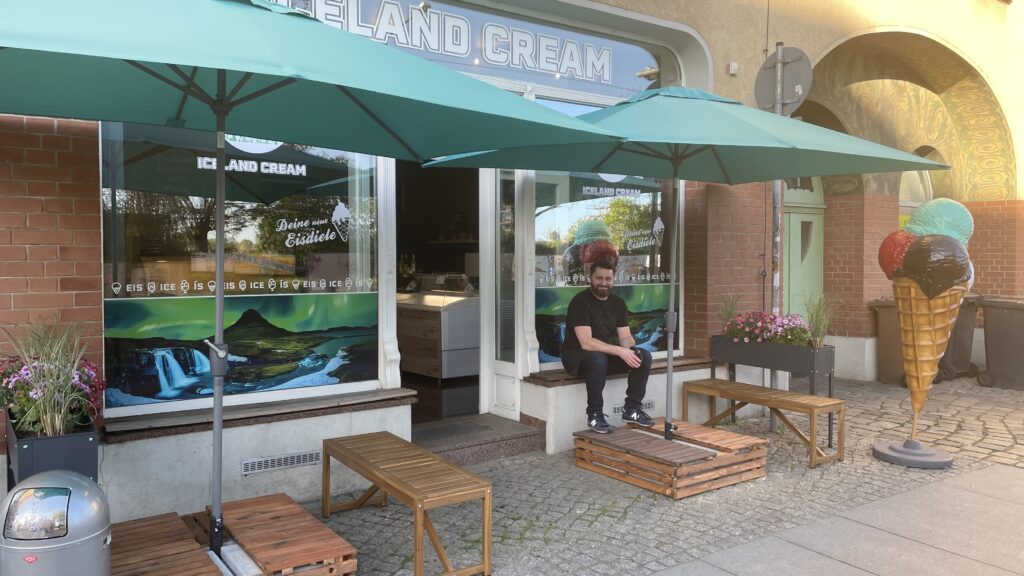 Der Außenbereich des Iceland Cream mit Sonnenschirmen und Bänken