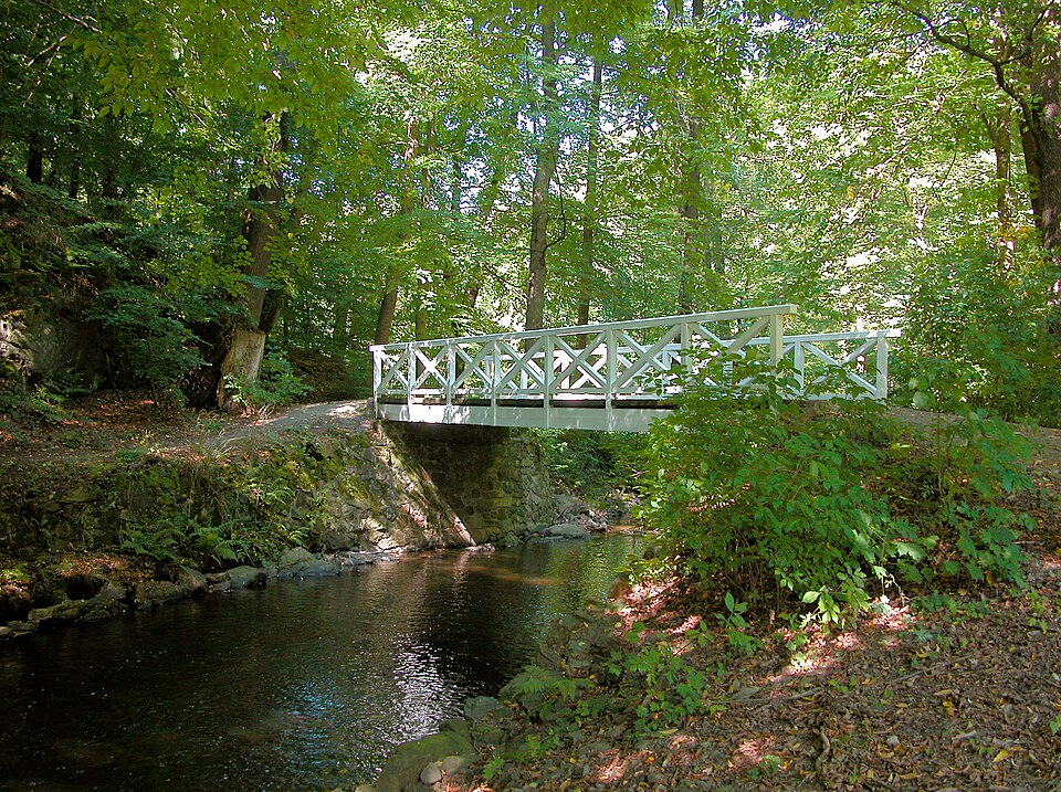 Weiße Holzfachwerkbrücke über der Röder im Seifersdorfer Tal