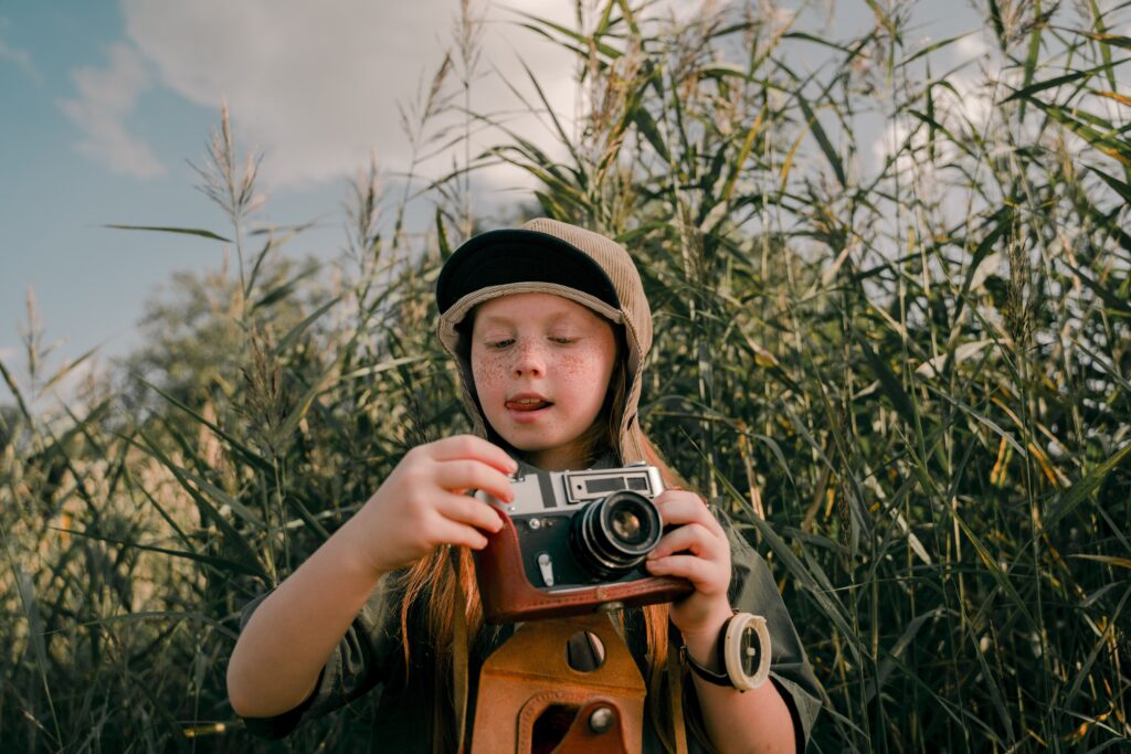 Junge mit Fotokamera in der Natur