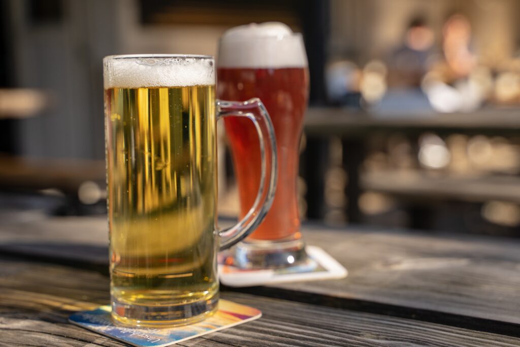 Auf dem Tisch stehen zwei Bier. Der Hintergrund ist verschwommen.